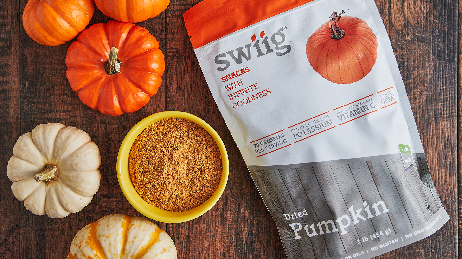 swiig Dried Pumpkin package on wood table next to several small pumpkins