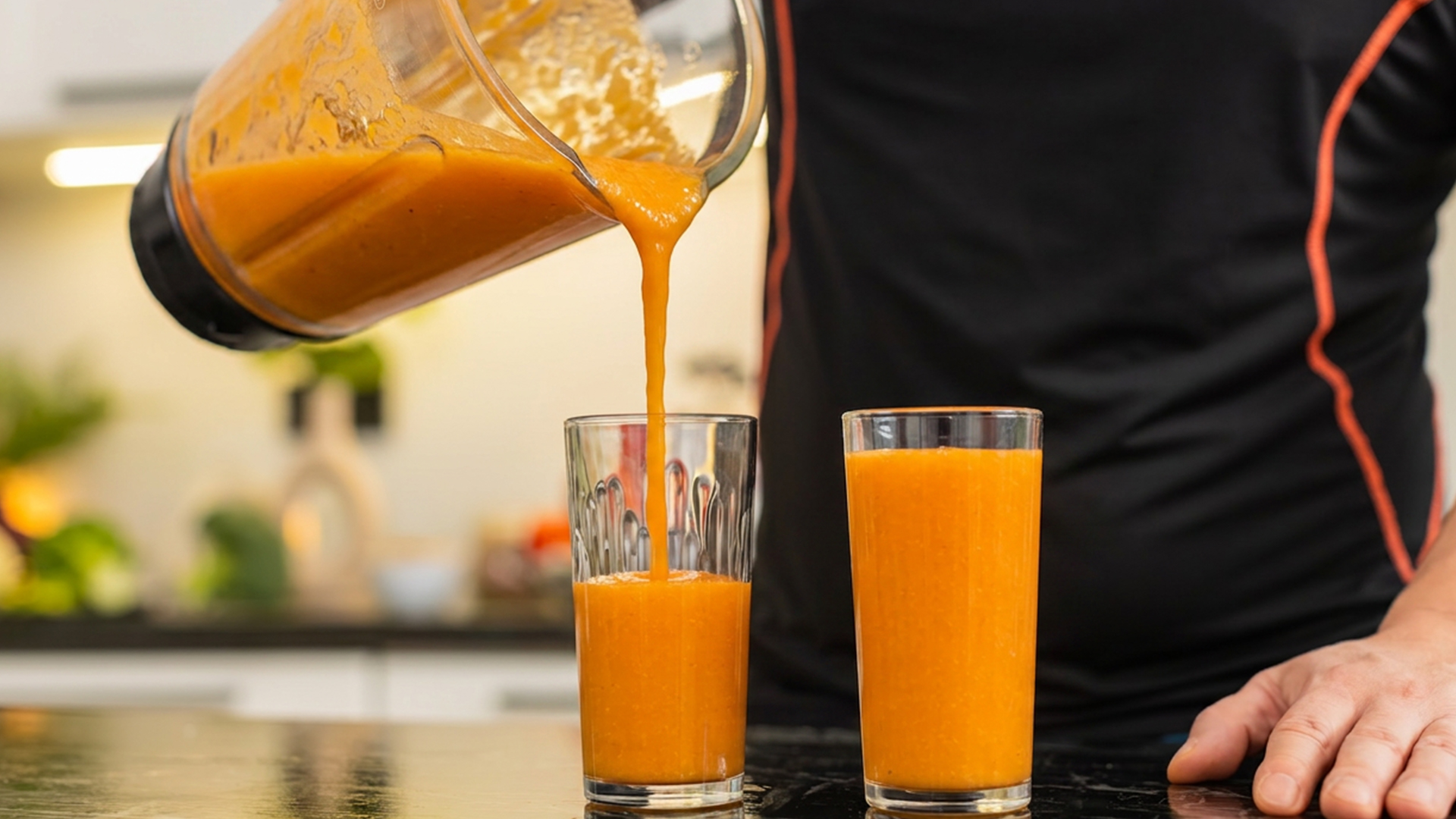 man behind gym smoothie counter pouring mango smoothie into glasses