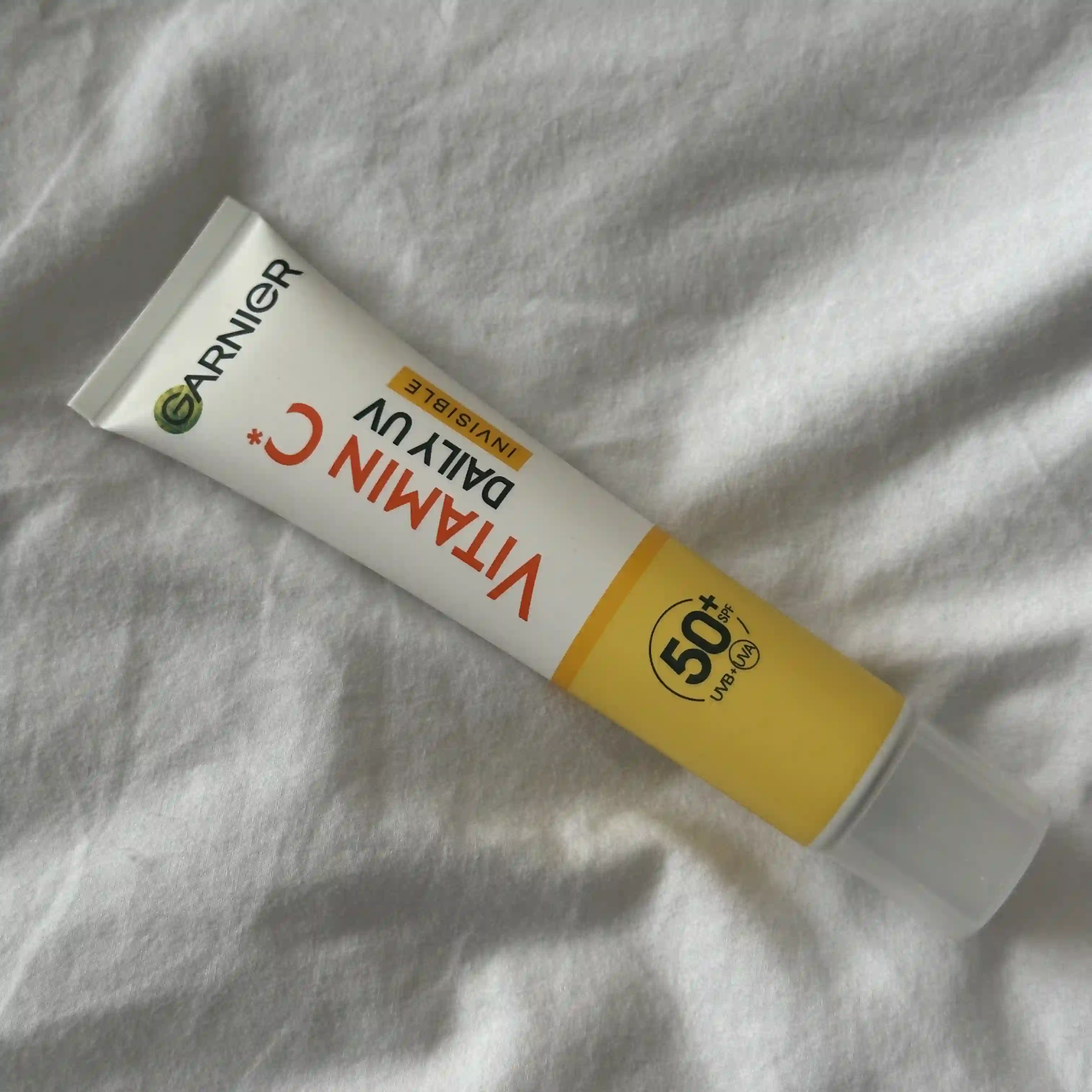 Image of Garnier Vitamin C Daily UV Brightening Fluid Invisible lying on a whitesheet