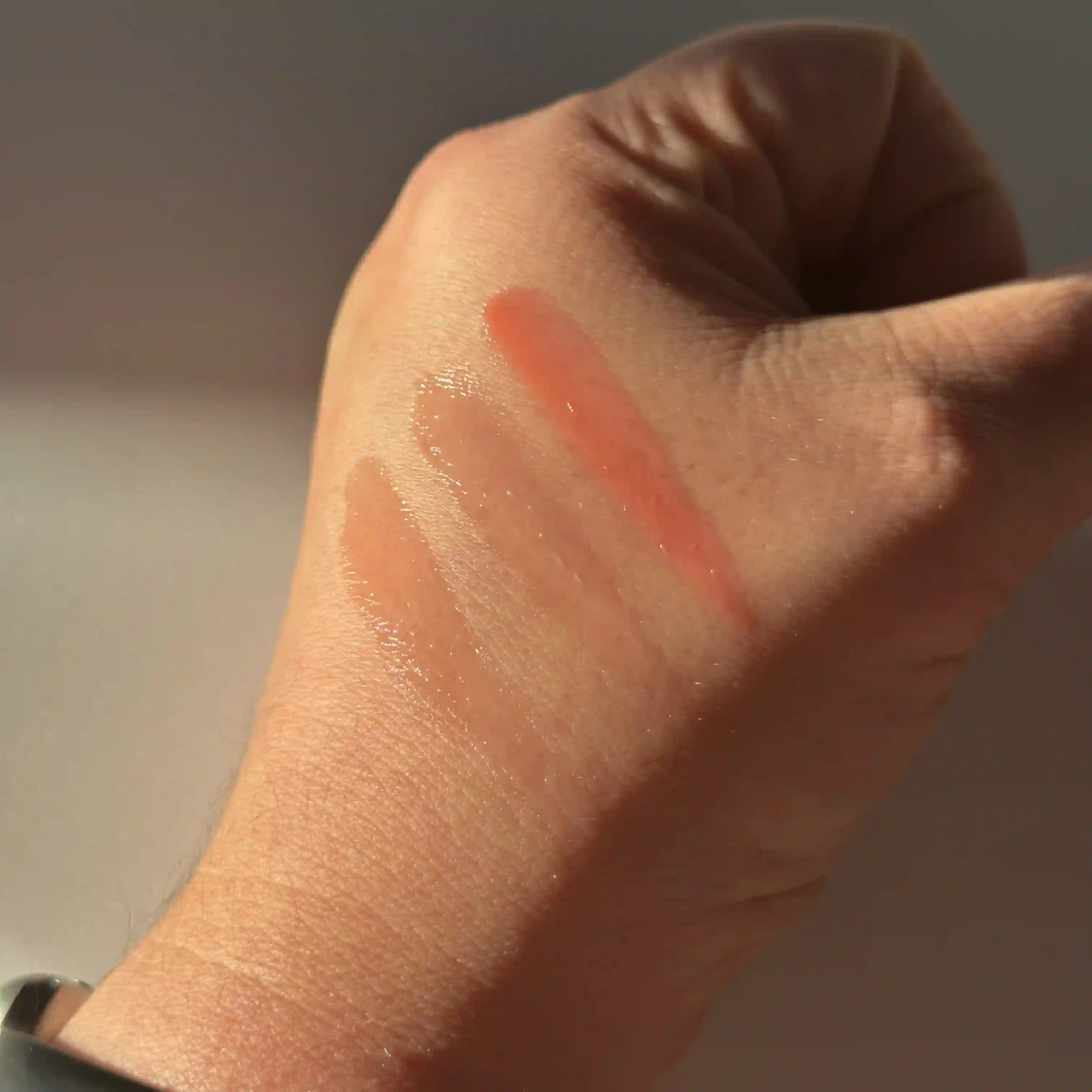 swatches of the Sheer LipTone shades on the side of writers hand against a white back ground in the sunlight