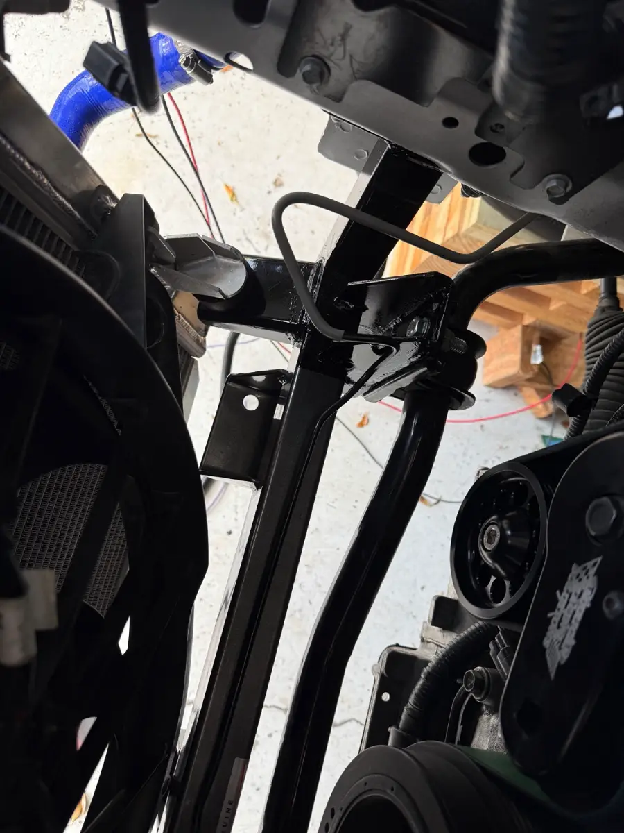 Front sway-bar bushing bracket attached to a custom lowered mounting plate on the Kenny Brown radiator support.