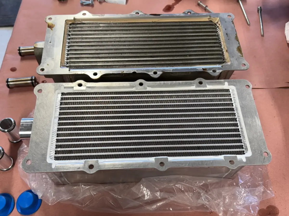 VMP intercooler core below the factory GT500 core, showing their finned surfaces and mounting flanges.