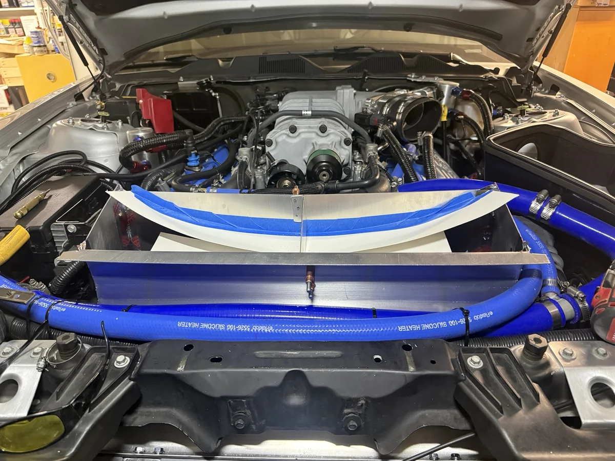 Center aluminum tie fitted across the GT500 outlet duct, with paper and tape protecting the opening from shavings.