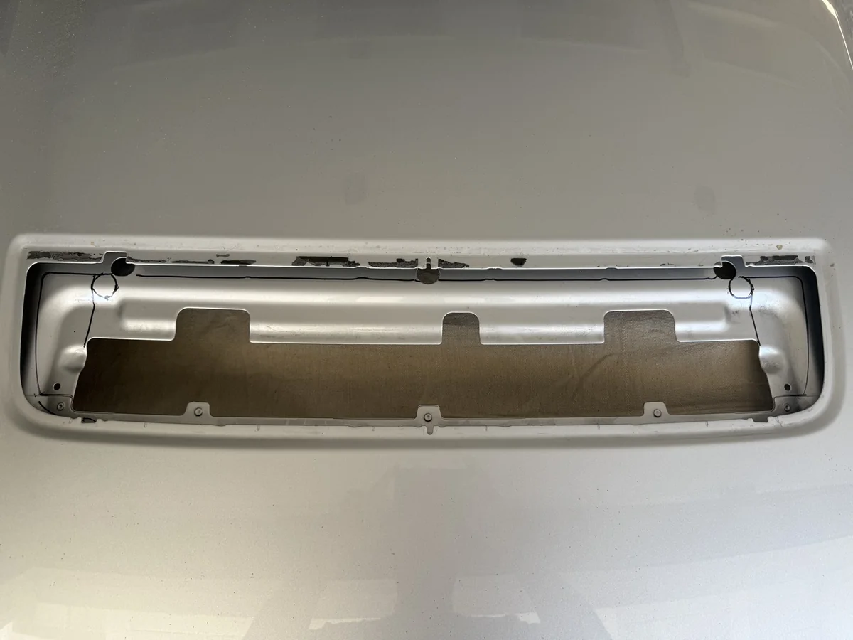 Marked cut lines on the aluminum hood around the factory GT500 vent opening, with a tarp underneath.