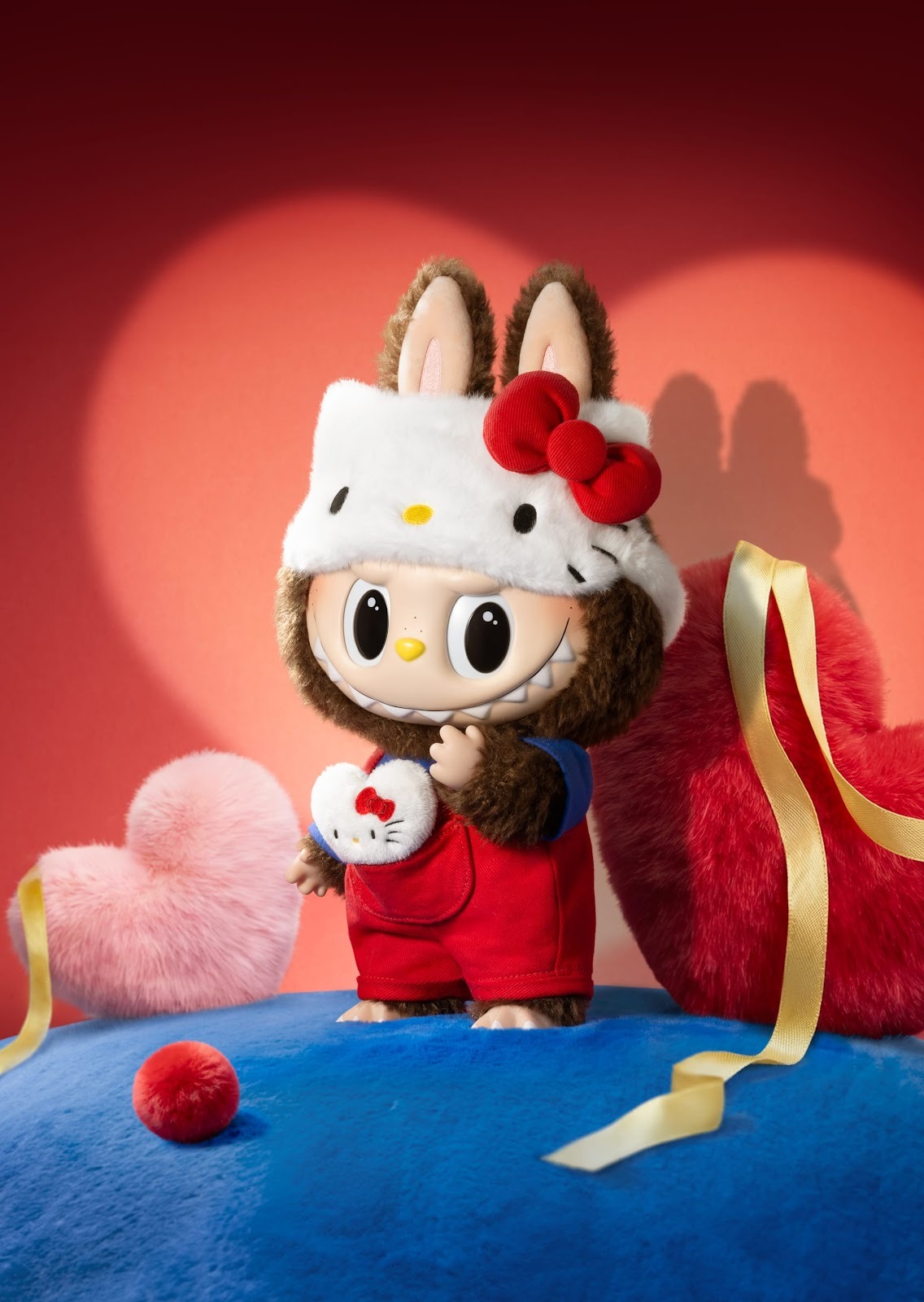 A cute character wearing a Hello Kitty-themed hat and red overalls, surrounded by plush hearts and ribbons on a colorful background.
