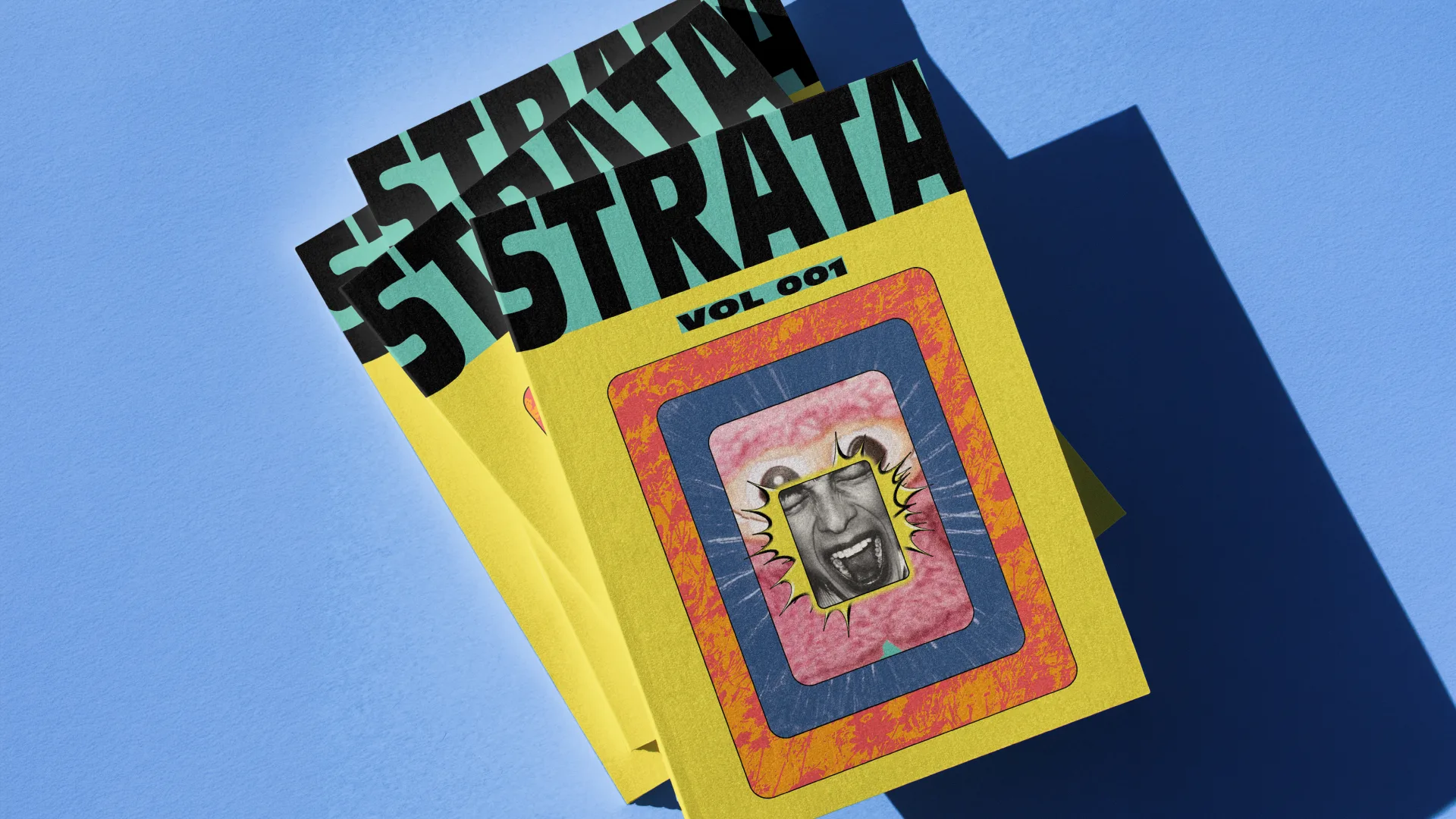 STRATA Vol 001 — stacked copies of the limited-edition print annual on blue