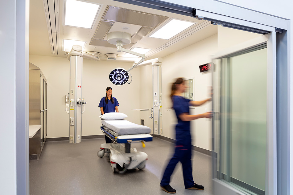 Adventist Health UVMC Ukiah Valley ED Expansion & ICU Addition, Ukiah, CA: Healthcare renovation, tenant improvement and new construction by Herrero Builders in an occupied environment, with Lionakis. Interior view of a patient room with a ceiling-mounted equipment boom and gurney.