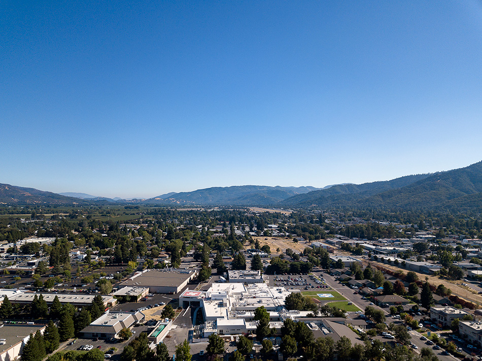 Adventist Health UVMC Ukiah Valley ED Expansion & ICU Addition, Ukiah, CA: Healthcare renovation, tenant improvement and new construction by Herrero Builders in an occupied environment, with Lionakis. Aerial view of the medical center campus in a valley with hills beyond.