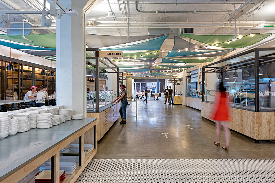 Airbnb Dining Commons & Commercial Kitchen, San Francisco, CA: Commercial & Retail renovation and tenant improvement by Herrero Builders with significant demolition, with WRNS Studio. Interior view of the servery with a salad bar and colorful fabric canopies overhead.