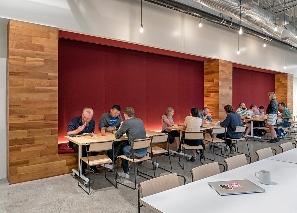Airbnb Dining Commons & Commercial Kitchen, San Francisco, CA: Commercial & Retail renovation and tenant improvement by Herrero Builders with significant demolition, with WRNS Studio. Interior view of a booth seating area with a red upholstered wall and wood paneling.