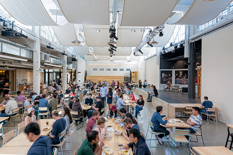 Airbnb Dining Commons & Commercial Kitchen, San Francisco, CA: Commercial & Retail renovation and tenant improvement by Herrero Builders with significant demolition, with WRNS Studio. Interior view of the assembly hall with white draped ceiling fabric and a stage.