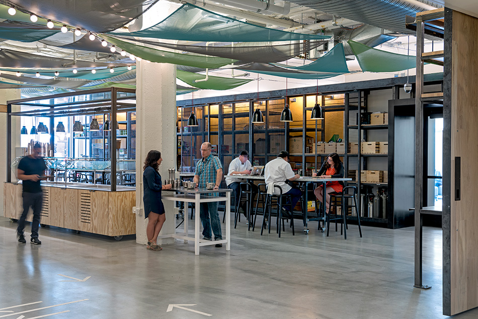 Airbnb Dining Commons & Commercial Kitchen, San Francisco, CA: Commercial & Retail renovation and tenant improvement by Herrero Builders with significant demolition, with WRNS Studio. Interior view of a servery counter and high-top tables under teal and gray canopies.
