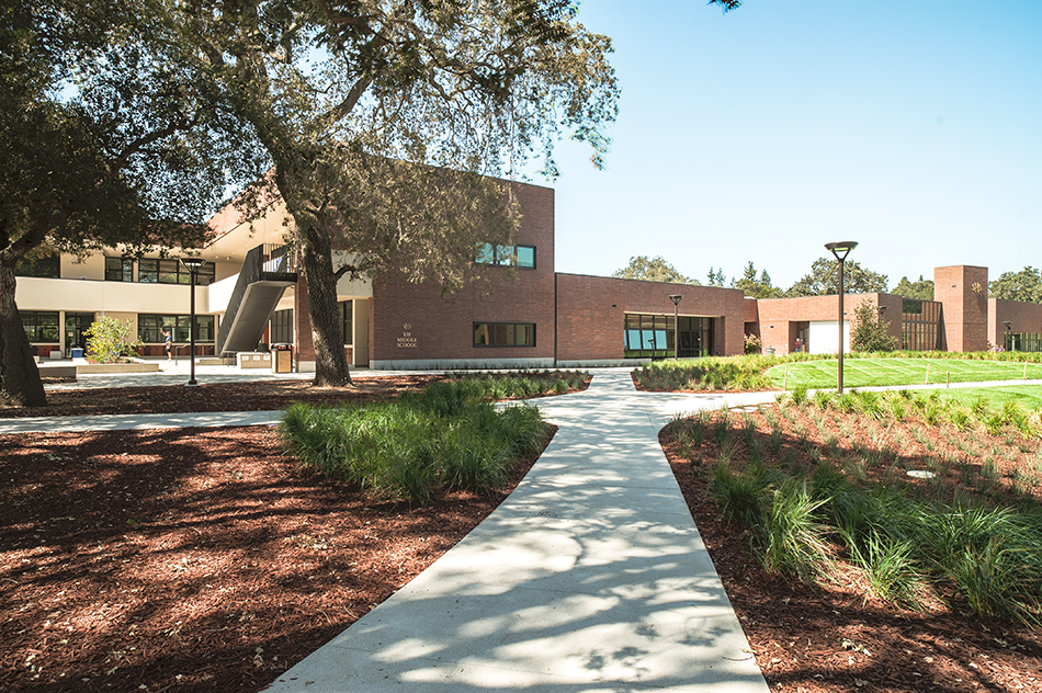 Sacred Heart Schools Atherton Lower & Middle School, Atherton, CA: Education new construction by Herrero Builders on a LEED Gold net zero energy campus, with WRNS Studio. Exterior view of the courtyard with a concrete path leading toward brick buildings under a mature oak.