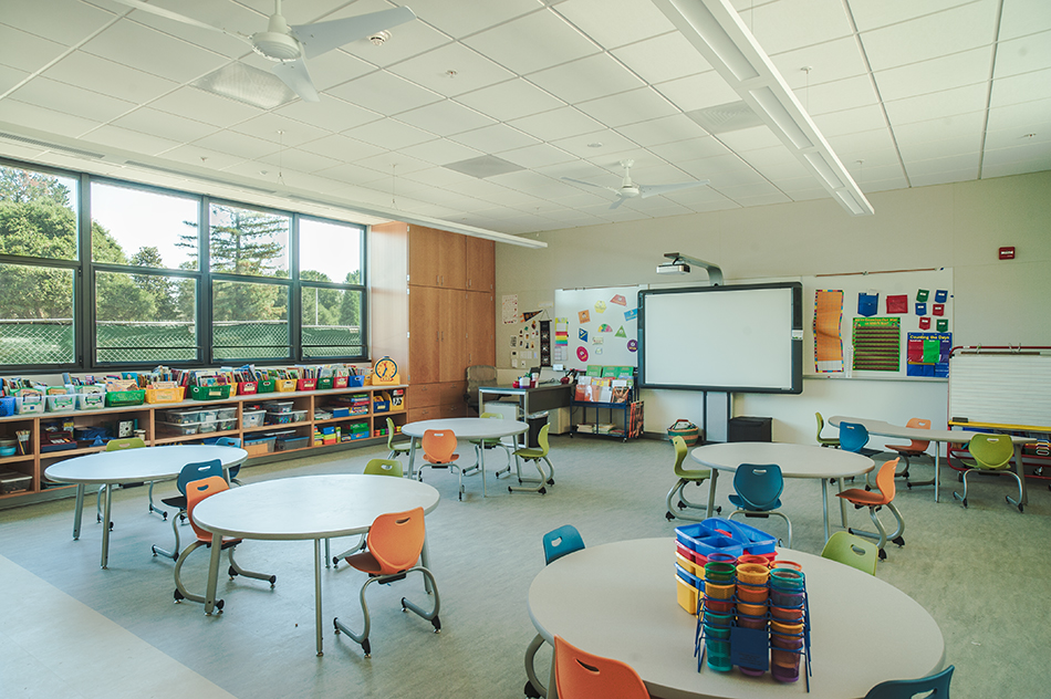 Sacred Heart Schools Atherton Lower & Middle School, Atherton, CA: Education new construction by Herrero Builders on a LEED Gold net zero energy campus, with WRNS Studio. Interior view of a bright classroom with round tables, colorful chairs and a wall-mounted display.