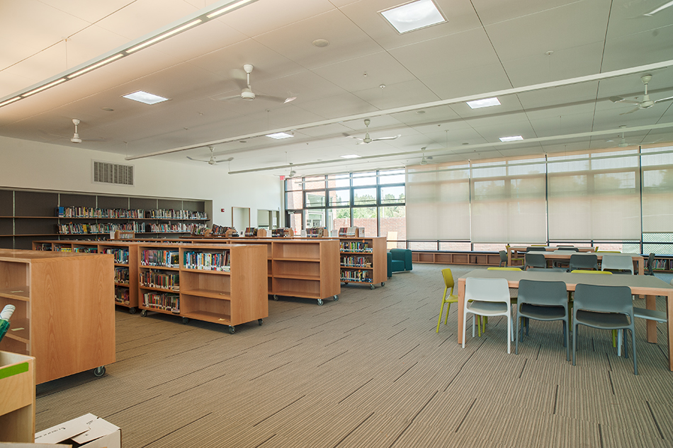 Sacred Heart Schools Atherton Lower & Middle School, Atherton, CA: Education new construction by Herrero Builders on a LEED Gold net zero energy campus, with WRNS Studio. Interior view of a library with low wood bookshelves on casters and long tables by large windows.