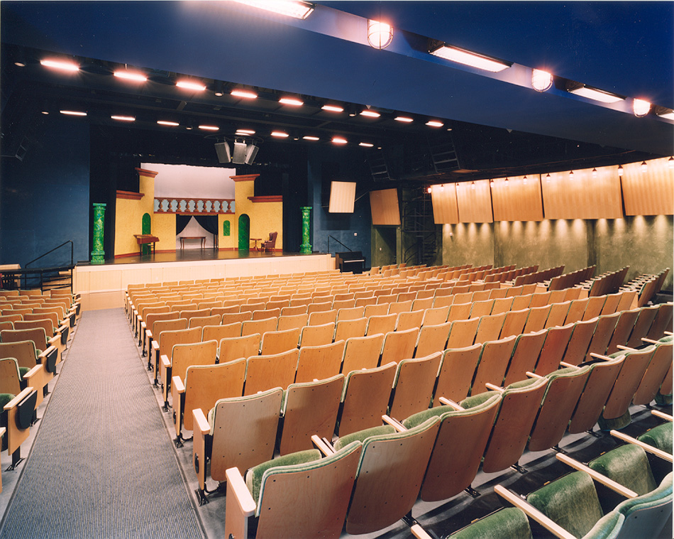 University High School Student Center, Upper & Lower Campuses, Ross, CA: Education New Construction and Renovation by Herrero Builders with historic preservation, with SMWM, Studio Bondy. Interior view of a tiered theater with wood seating and a stage set.