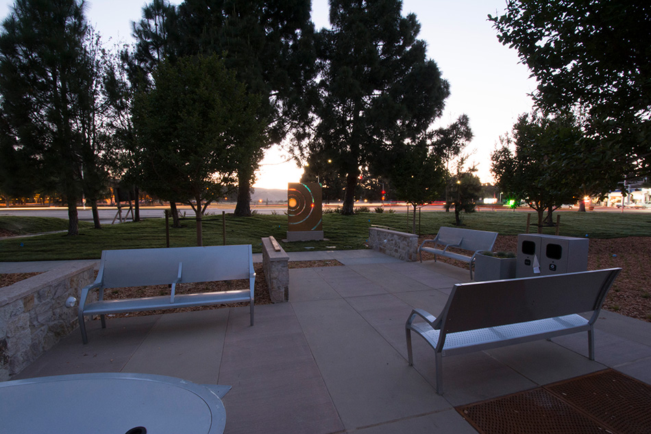 Sutter Health PAMF Fremont Ambulatory Surgery Center & Parking Garage, Fremont, CA: Healthcare New Construction by Herrero Builders in an occupied healthcare environment, with Boulder Architects. Site view of a landscaped patio with metal benches, stone seat walls and trees at sunset.
