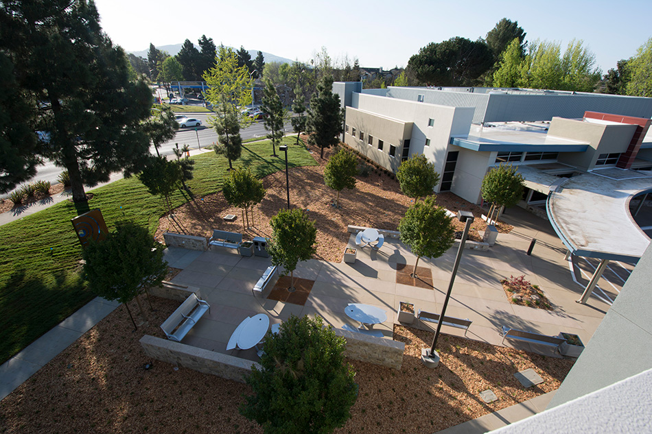 Sutter Health PAMF Fremont Ambulatory Surgery Center & Parking Garage, Fremont, CA: Healthcare New Construction by Herrero Builders in an occupied healthcare environment, with Boulder Architects. Aerial view of a landscaped courtyard with benches beside the surgery center from an elevated vantage.