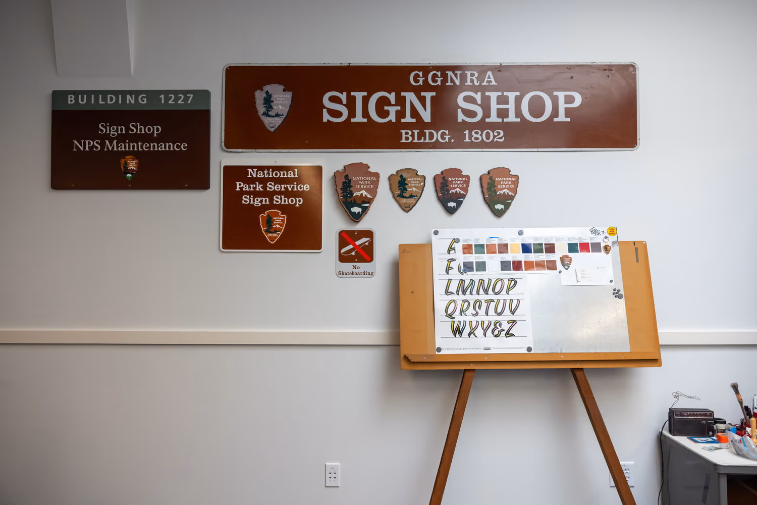 National Park Service Crissy Field Hangar Rehabilitation (Presidio Building 643), San Francisco, CA: Historic renovation by Herrero Builders using Lean construction, with Siegel & Strain Architects. Interior view of a sign shop wall with park service signs and a lettering easel.