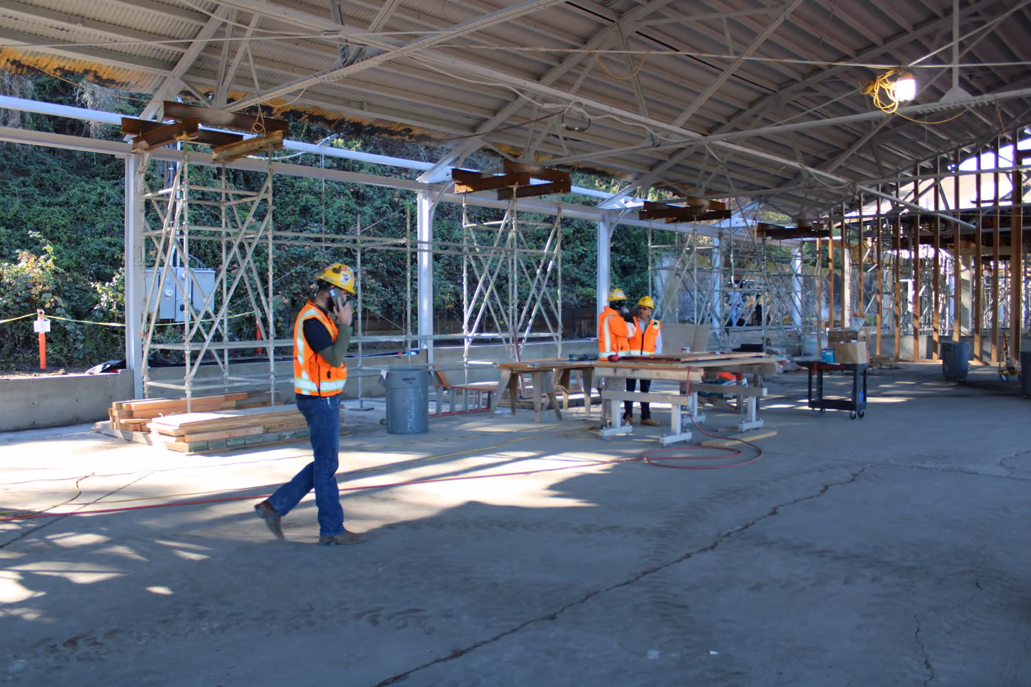 National Park Service Crissy Field Hangar Rehabilitation (Presidio Building 643), San Francisco, CA: Historic renovation by Herrero Builders using Lean construction, with Siegel & Strain Architects. Construction-phase view of the open hangar with scaffolding and workers in hard hats.