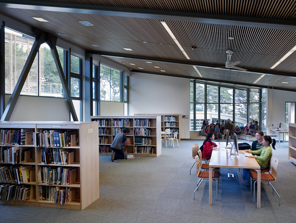 Nueva School Hillside Learning Complex & Historic Crocker Mansion, Hillsborough, CA: Education and Historic new construction and renovation by Herrero Builders earning LEED Gold, with Leddy Maytum Stacy Architects. Interior view of a library with a wood-slat ceiling and bookshelves.