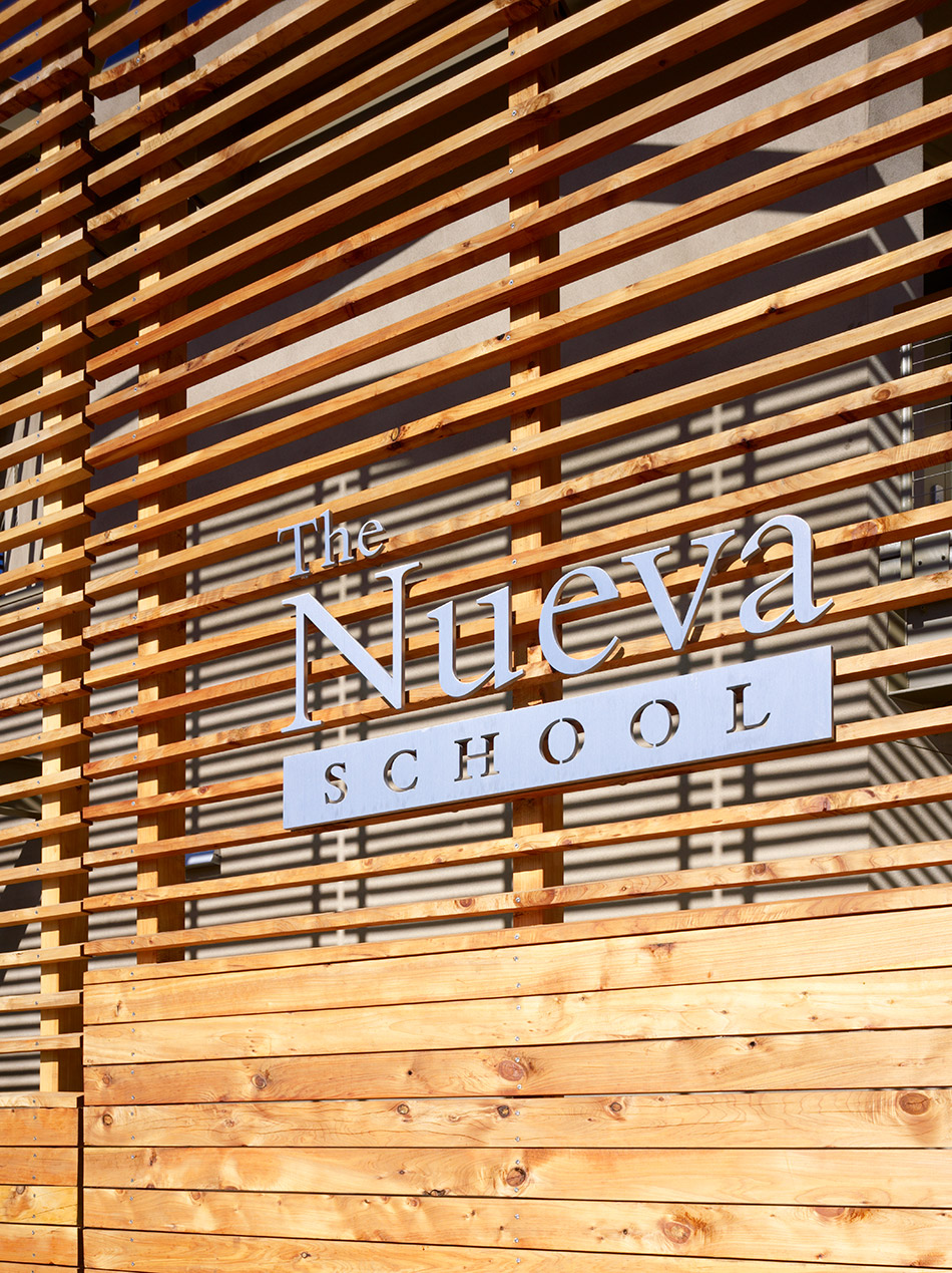 Nueva School Hillside Learning Complex & Historic Crocker Mansion, Hillsborough, CA: Education and Historic new construction and renovation by Herrero Builders earning LEED Gold, with Leddy Maytum Stacy Architects. Detail of a timber slat wall with a metal school sign.