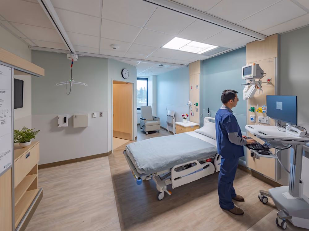 Sutter Health Santa Rosa Regional Hospital Expansion, Santa Rosa, CA: Healthcare New Construction by Herrero Builders under Integrated Project Delivery with Lean construction, with Stantec. Interior view of a private patient room with a hospital bed, monitor and a staff member at a computer.