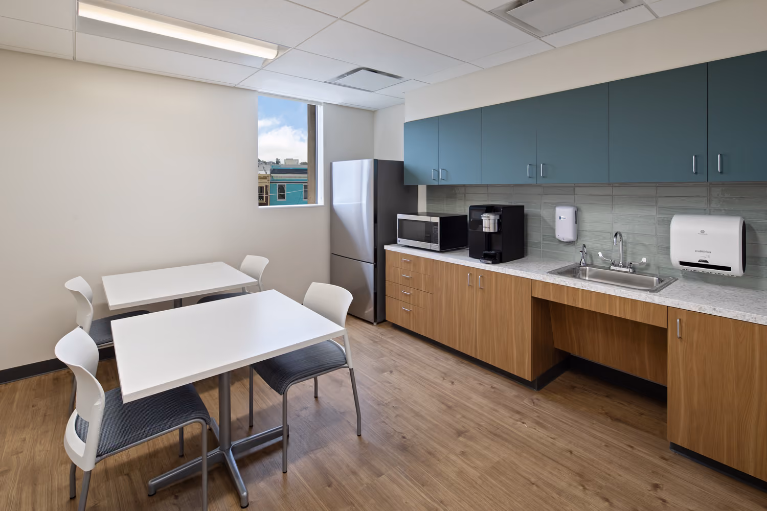 Sutter Health Monteagle Multispecialty Center, San Francisco: Healthcare multi-floor tenant improvement by Herrero Builders occupied during construction, with Polytech Architects and HED. Interior view of a staff break room with a kitchenette, small tables and chairs.