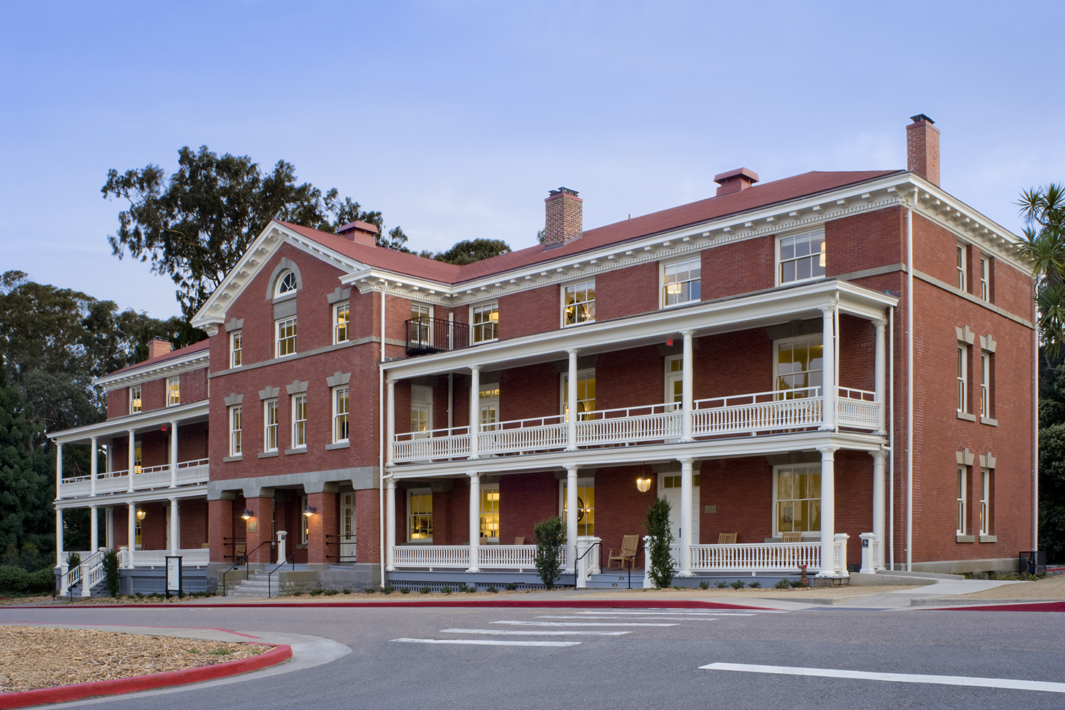 The Presidio Trust Inn at the Presidio, San Francisco, CA: Hospitality and Historic renovation by Herrero Builders preserving a National Historic Landmark, with Architectural Resources Group. Exterior view of the brick building and wraparound porches from the street corner.