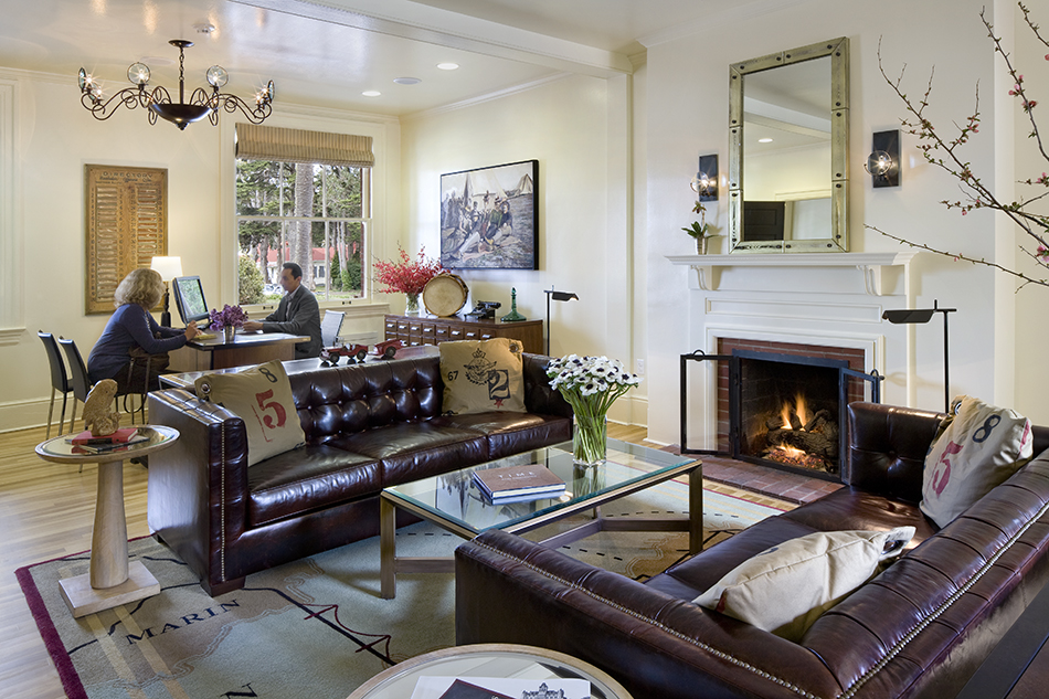 The Presidio Trust Inn at the Presidio, San Francisco, CA: Hospitality and Historic renovation by Herrero Builders preserving a National Historic Landmark, with Architectural Resources Group. Interior view of a lobby lounge with leather sofas, a fireplace and a front desk.