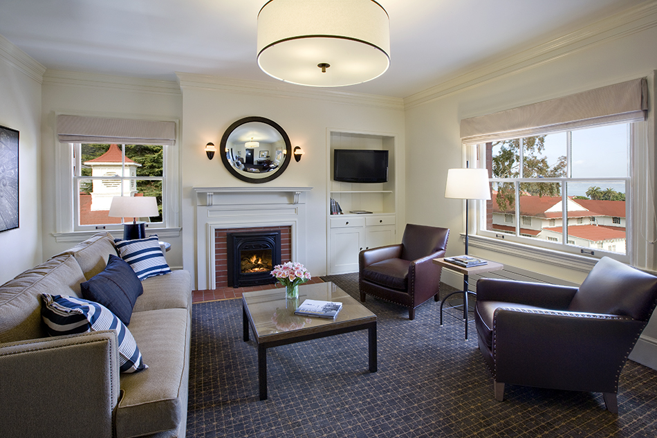 The Presidio Trust Inn at the Presidio, San Francisco, CA: Hospitality and Historic renovation by Herrero Builders preserving a National Historic Landmark, with Architectural Resources Group. Interior view of a guest suite sitting room with a fireplace, sofa and leather armchairs.
