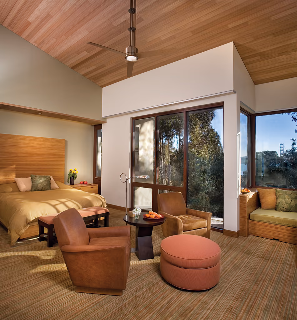 Fort Baker Retreat Group Cavallo Point Lodge & Spa, Sausalito, CA: Hospitality renovation and new construction by Herrero Builders in a historic landmark, with Leddy Maytum Stacy Architectural Resources Group. Interior view of a guest suite with a bed, armchairs and a bridge tower in the window.