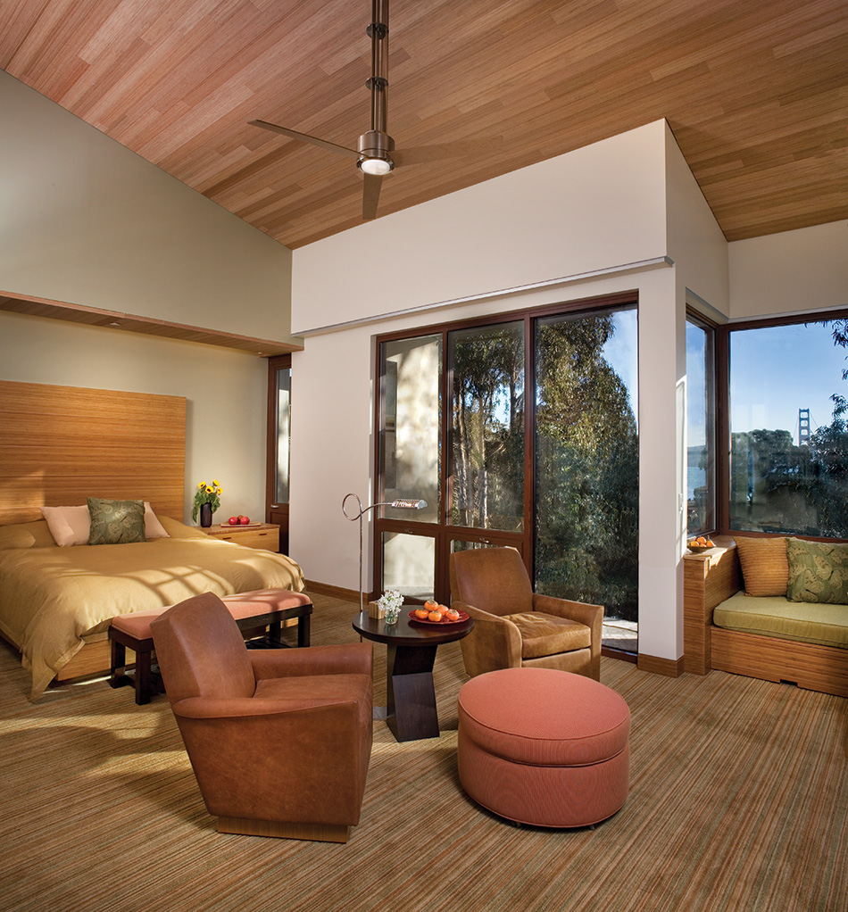Fort Baker Retreat Group Cavallo Point Lodge & Spa, Sausalito, CA: Hospitality renovation and new construction by Herrero Builders in a historic landmark, with Leddy Maytum Stacy Architectural Resources Group. Interior view of a guest suite with a bed, armchairs and a bridge tower in the window.
