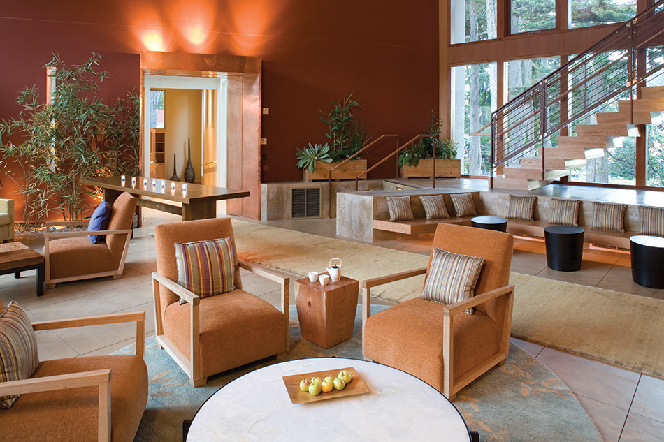 Fort Baker Retreat Group Cavallo Point Lodge & Spa, Sausalito, CA: Hospitality renovation and new construction by Herrero Builders in a historic landmark, with Leddy Maytum Stacy Architectural Resources Group. Interior view of a lounge with orange armchairs, bamboo plants and a stair.