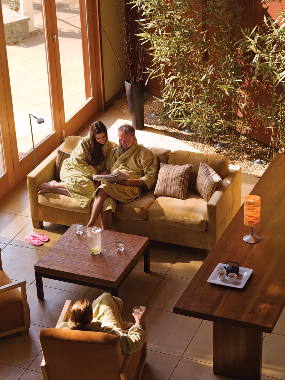 Fort Baker Retreat Group Cavallo Point Lodge & Spa, Sausalito, CA: Hospitality renovation and new construction by Herrero Builders in a historic landmark, with Leddy Maytum Stacy Architectural Resources Group. Interior view of a relaxation room with a sofa, bamboo planter and tall windows.