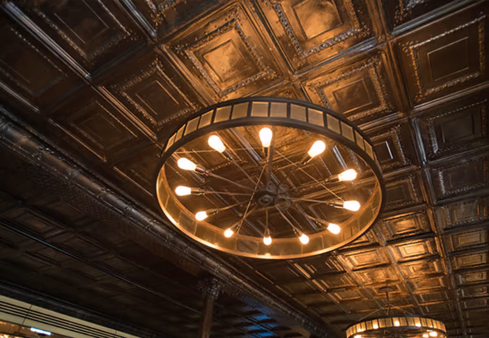 Fort Baker Retreat Group Murray Circle Restaurant, Sausalito, CA: Hospitality and Historic renovation and new construction by Herrero Builders, with Leddy Maytum Stacy Architects. Detail of a pressed-tin ceiling with a wheel-shaped pendant light.