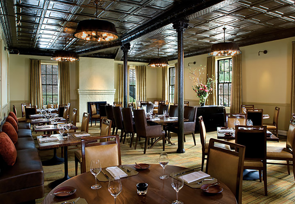 Fort Baker Retreat Group Murray Circle Restaurant, Sausalito, CA: Hospitality and Historic renovation and new construction by Herrero Builders, with Leddy Maytum Stacy Architects. Interior view of a dining room with round tables and a leather banquette.