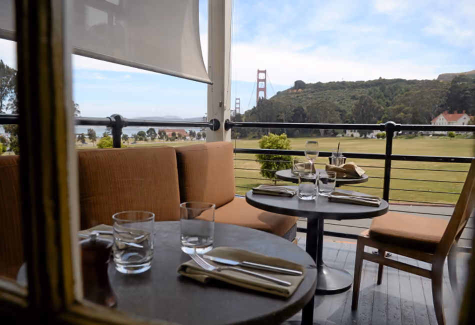 Fort Baker Retreat Group Murray Circle Restaurant, Sausalito, CA: Hospitality and Historic renovation and new construction by Herrero Builders, with Leddy Maytum Stacy Architects. Interior view of a terrace table setting with a view of the Golden Gate Bridge.