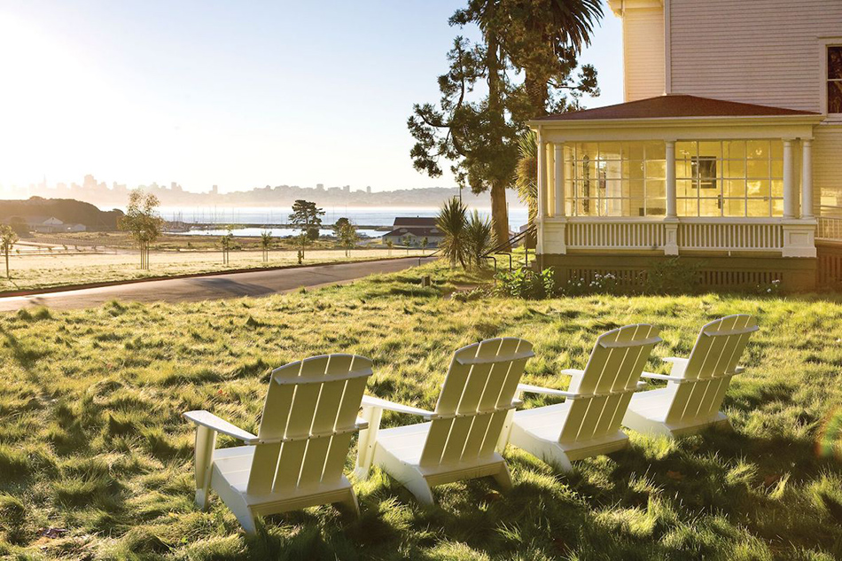 Fort Baker Retreat Group Murray Circle Restaurant, Sausalito, CA: Hospitality and Historic renovation and new construction by Herrero Builders, with Leddy Maytum Stacy Architects. Exterior view of white Adirondack chairs on the lawn before a historic porch.