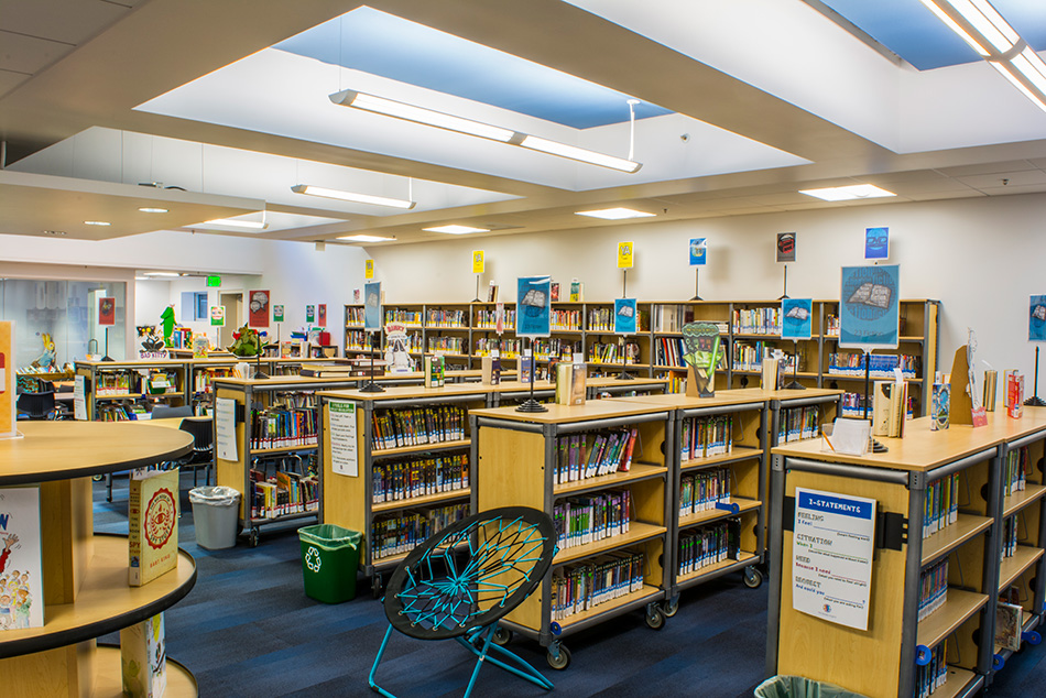 Town School for Boys Core Building & West Wing Excavation, San Francisco, CA: Education New Construction by Herrero Builders with significant excavation on an occupied campus, with MKThink. Interior view of the library with wood-and-metal book stacks and recessed ceiling light panels.