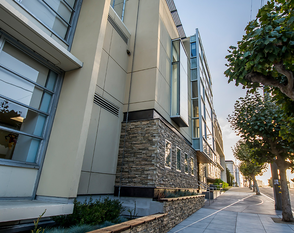 Town School for Boys Core Building & West Wing Excavation, San Francisco, CA: Education New Construction by Herrero Builders with significant excavation on an occupied campus, with MKThink. Exterior view of the building corner with a stone base, metal panels and windows along the street.