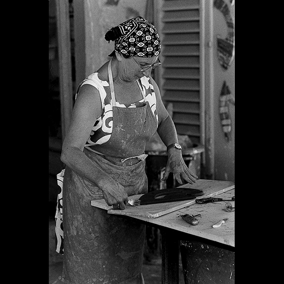 Image details: 1. Betty Woodman at work in her studio in Antella, Italy, 1996. Photograph by George Woodman | 2. An assemblage of Betty Woodman’s studio materials. Clockwise from bottom left: Rocket Expansion cement, broken ceramic pieces, measuring cup, sponges, Orton standard pyrometric cones (open box) Orton small pyrometric cones, fork, toothbrush, kitchen knife | 3. George Woodman in his New York City studio c. 1980s | 4. An assemblage of George Woodman’s studio materials. Clockwise from bottom left: Gorton vapor equalizing valve, Bessey vise clamp, Xcemite screw driver, rubber hook tool, Dap silicone, GE silicone, Stanley level, Conair hair dryer, Wiss pliers, Great Neck wood chisel, Maimeri set of paints