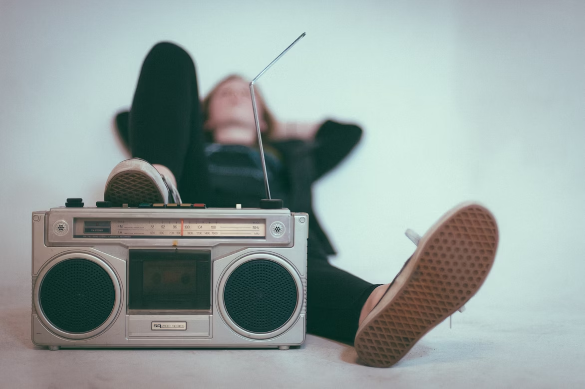 Woman laying down near a gray radio.