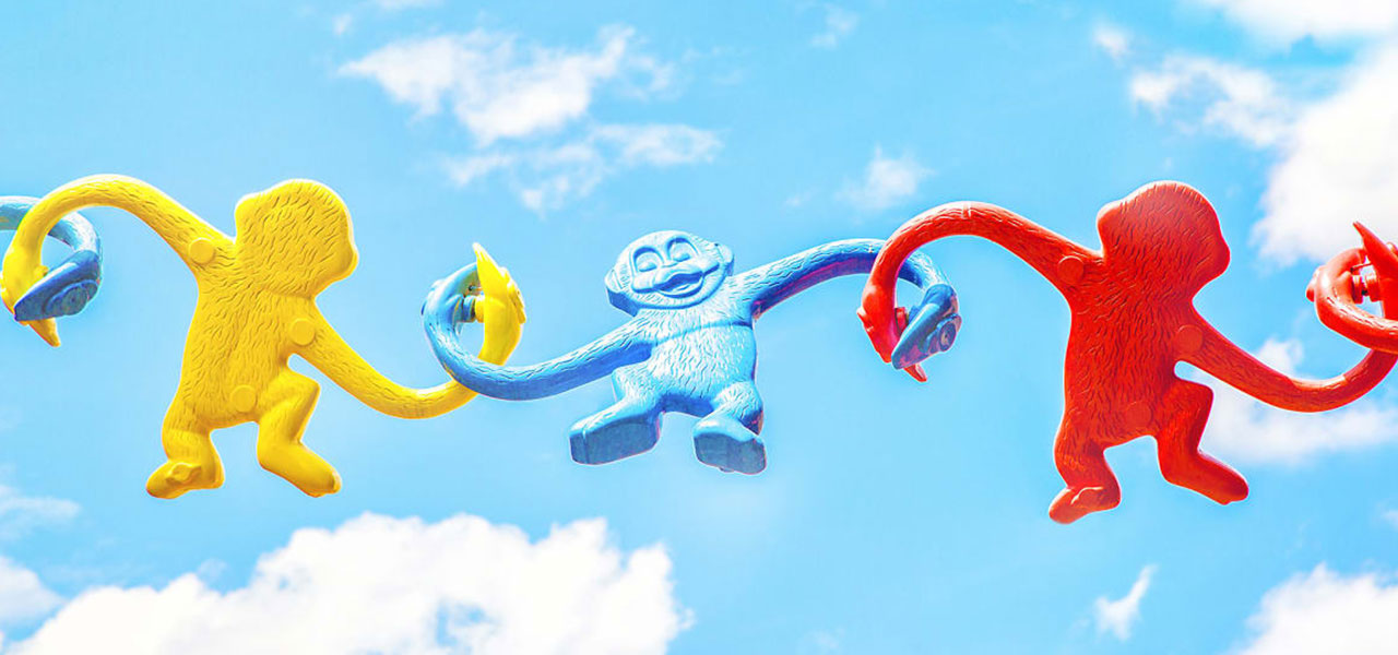 Toy monkeys linking hands to symbolize connection.