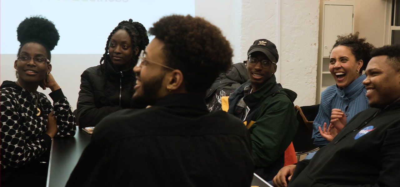 A group of young Black creatives gathered around a table.