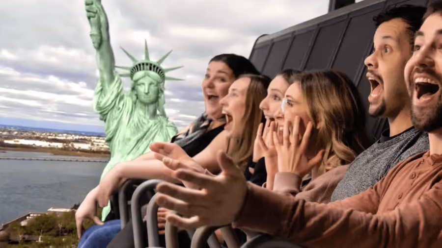 A group of people riding the RiseNY 4D attraction, they are smiling and enjoying the ride.