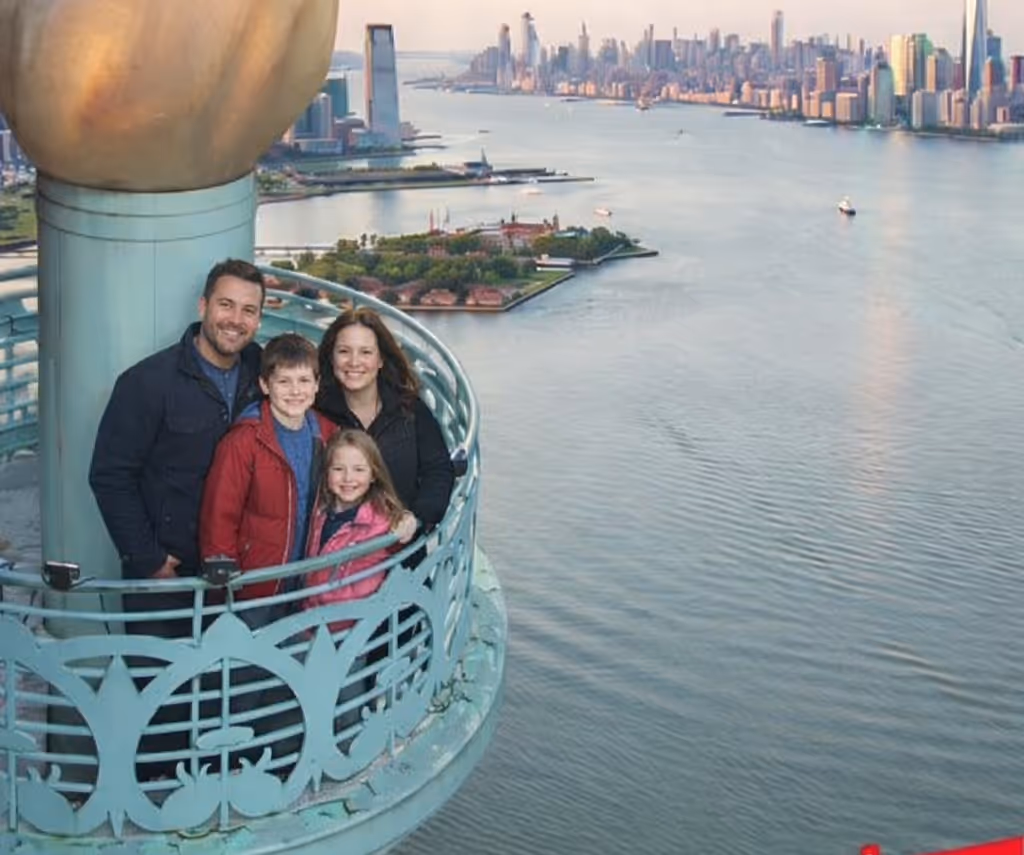 A family standing and smiling for a picture on the RiseNY torch