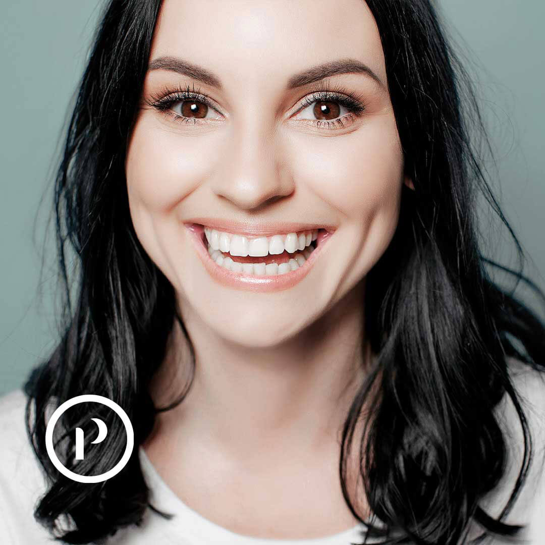 Platineers Smile. Young woman smiling on light green background.