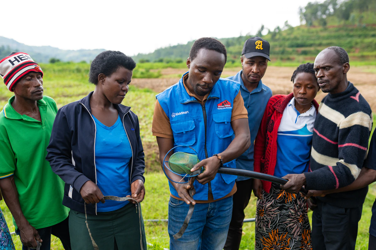 A KickStart field officer demonstrates irrigation equipment to a group of smallholder farmers in rural Rwanda.