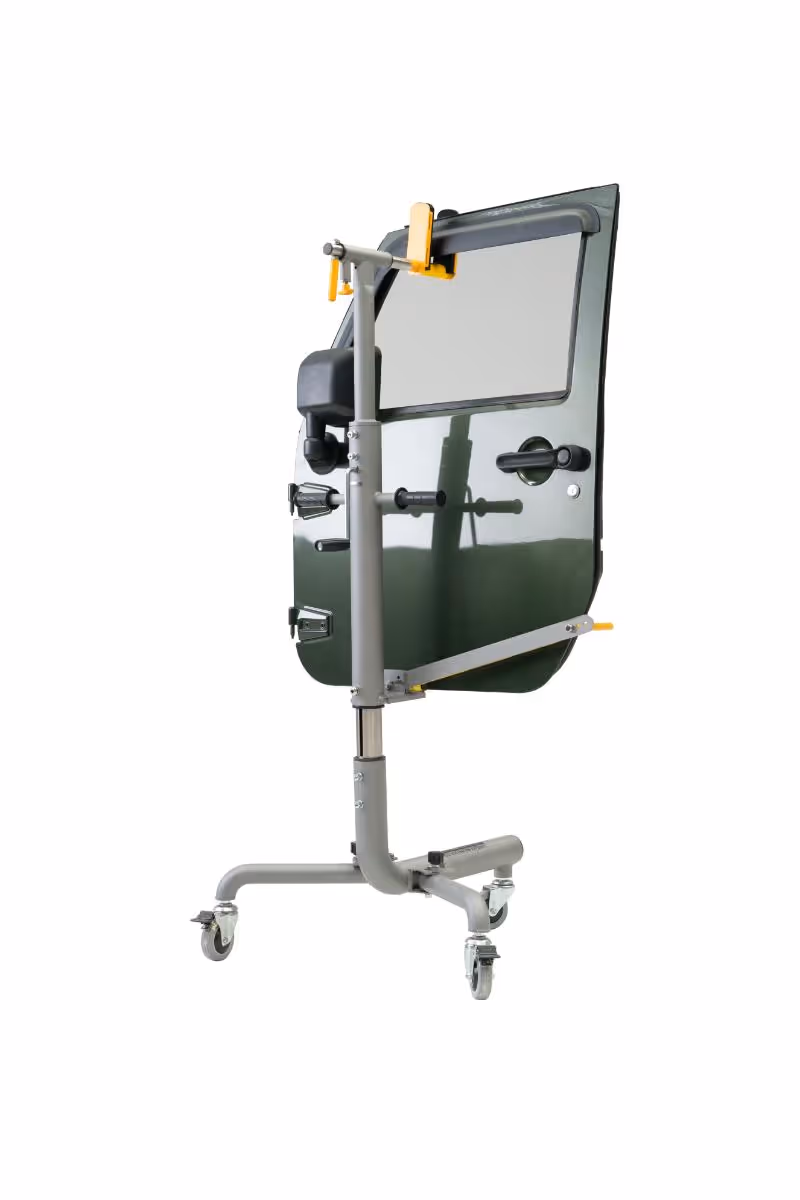 Dark green car door mounted on a gray wheeled adjustable stand with clamps and handles.